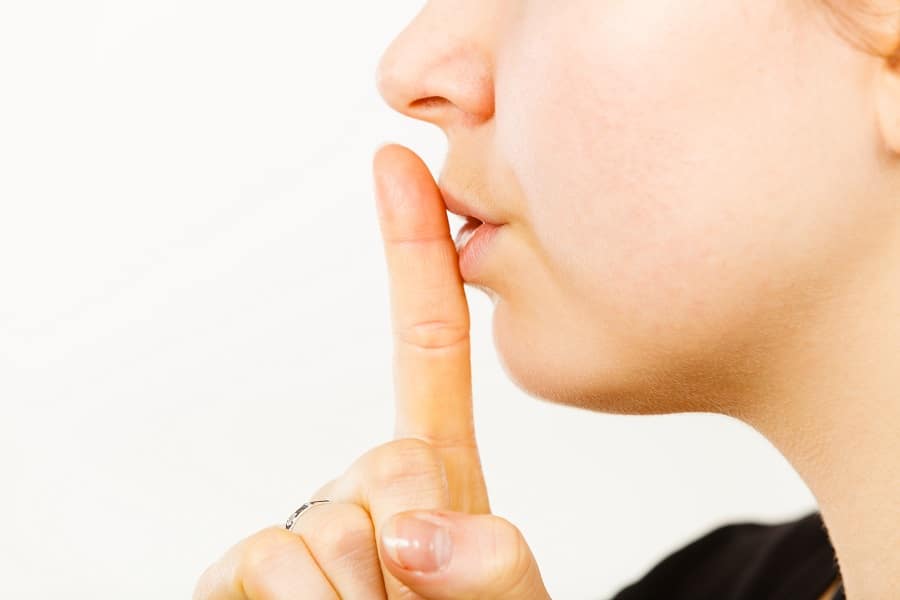 Woman Showing Silence Shh Gesture With Finger Close To Mouth Ask